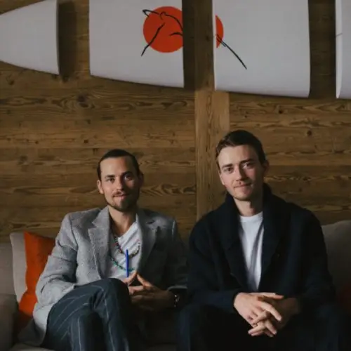 Two men sitting and smiling at the camera | Co-Impact.