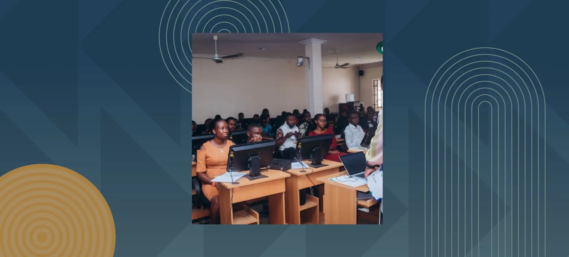 Students in lecture hall with laptops attending academic presentation or workshop session