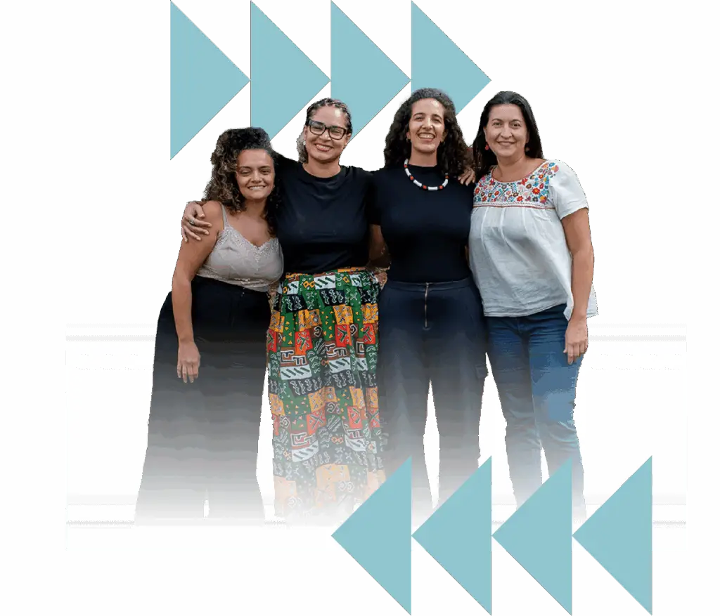 Four women smiling and embracing as a group | Co-Impact.