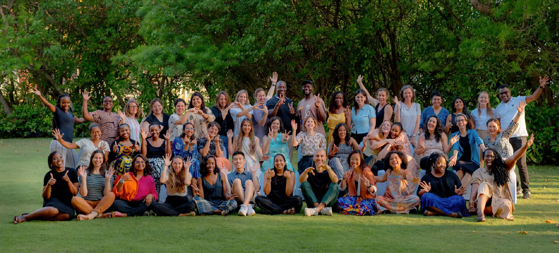 This image shows members of the Co-Impact team standing together, smiling and holding signs during an event. It reflects the organization’s commitment to collective action and inclusive systems change.